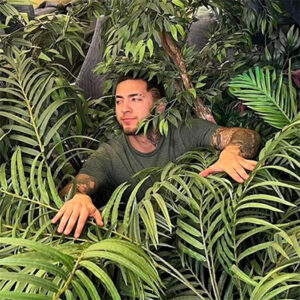 A Ninaxandra Inc mover is surrounded by leafy plants in a moving truck.